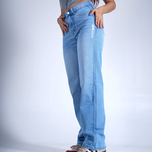 Person wearing a silver crop top and blue jeans on a white background